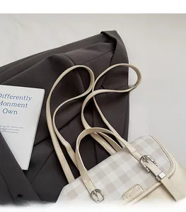 Close-up of cream checkered backpack with fashion logo and decorative metal buckle