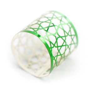 Detailed macro shot of reflective green metal napkin ring with star cutout patterns