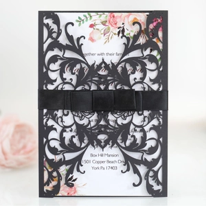 Elegant laser cut black wedding invitation with ribbon bow and floral inner card