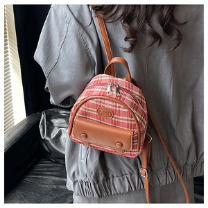 Mini plaid backpack featuring red and brown fabric with leather straps on a model back