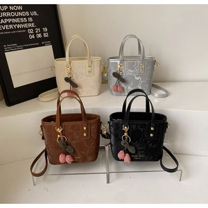 Detail of mini bucket bags in four colors with marble texture and cherry charms