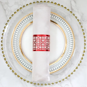Elegant red laser-cut floral napkin ring with white satin cloth on marble table