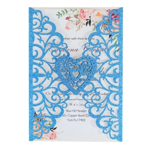 Macro shot of laser-cut wedding invitation with blue glitter finish and floral inner card