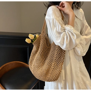 Detailed texture of brown handmade crochet shoulder bag showing the hollow weave pattern