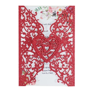 Detail of red glitter laser-cut invitation with heart patterns and floral inner card
