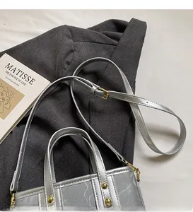 Detailed view of silver bucket bag with gold accents and adjustable shoulder strap