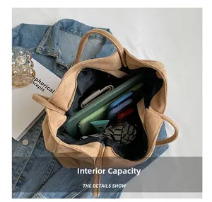 Detailed view of the interior capacity of a large camel suede tote bag with items
