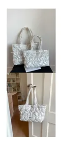 Detail view of heart quilted white tote bags in two sizes with soft glossy texture
