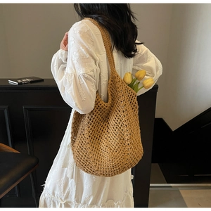Detail of hand-woven hollow out shoulder bag with bohemian mesh and yellow tulips