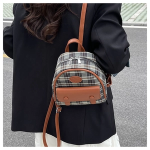 British style mini plaid backpack with brown leather trim worn by model outdoors