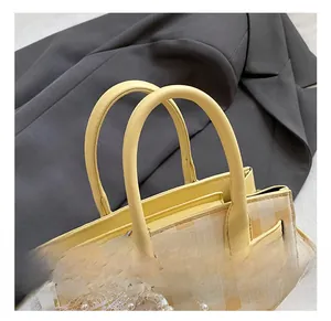 Detail of yellow checkered bucket bag with pearl chain and elegant metal twist lock