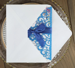 Laser cut glitter blue wedding invitation with silk bow and floral inner card detail