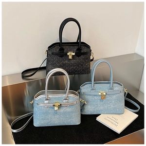 Detail view of denim bucket bags in black sequins and blue fabric with metallic hardware