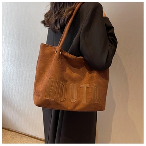 Close-up of the brown suede tote bag with HOOTO embroidered lettering and leather texture