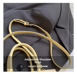 Detail of adjustable pale yellow synthetic leather shoulder strap with silver buckle