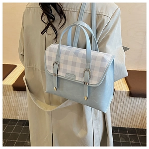 Detail showing light blue plaid flap and silver buckles on a retro college style backpack