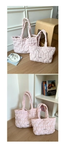 Detail view of heart-quilted texture and magnetic clasp on pink puffer tote bags