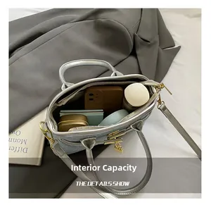 Spacious interior of silver glitter bucket bag showing storage for cosmetics and phone