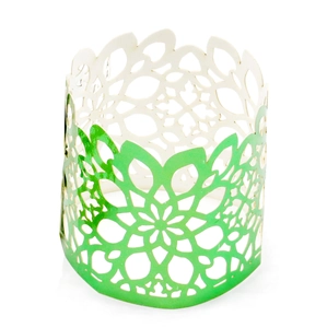 Macro shot of green laser-cut paper napkin ring with intricate floral mandala patterns
