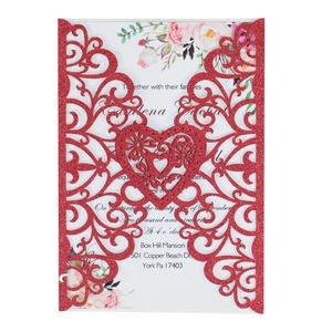 Detail of red glitter laser-cut wedding invitation cover with intricate floral pattern