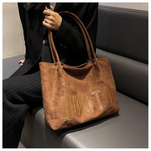 Detailed view of the brown suede tote bag with stitched HOOTO letter embroidery