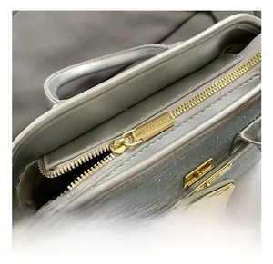 Detailed macro shot of the golden zipper puller and metallic finish on a bucket bag