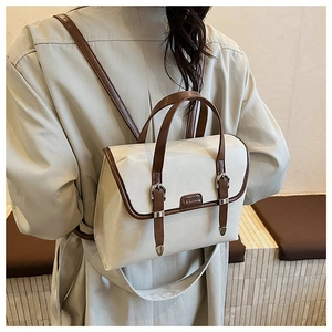 Close-up of cream British retro backpack with brown leather trim and metal buckles