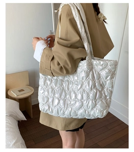 Close-up of heart-shaped quilted pattern and silver metallic bow on a tote bag
