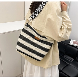 Detailansicht der gewebten schwarz-weiß gestreiften Tasche mit geometrischem Gurt