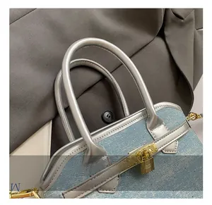 Detailed view of blue denim bucket bag with sparkling rhinestones and silver handle strap