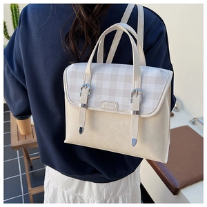 Detail of vintage cream PU leather and plaid backpack with adjustable metal buckles