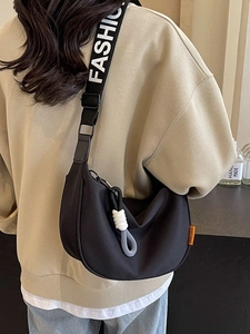 Black crescent canvas crossbody bag with white FASHION letter strap and rope charm