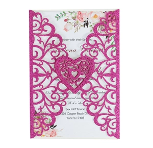 Detail of laser cut wedding invitation with pink glitter finish and floral insert