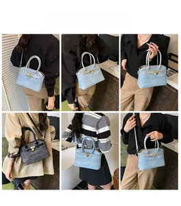 Detail view of denim bucket bag with metal turn-lock and handle shown on a fashion model