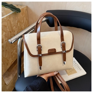Detail of British retro backpack in cream and brown PU leather with silver buckle