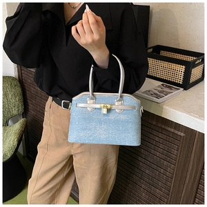 Detail of light blue glitter crossbody bag with silver handles and gold padlock