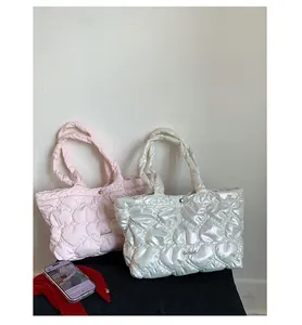 Close-up of quilted heart pattern on padded nylon tote bags with metallic logo