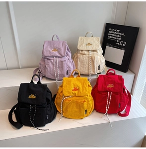 Detailed arrangement of nylon drawstring backpacks in five colors on a white display stand