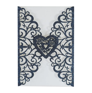 Detail showing dark blue glitter laser-cut invitation with intricate heart design