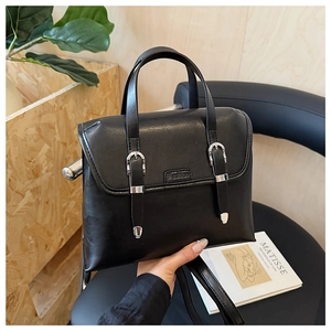 Close-up of black PU leather handbag with silver buckles and Fashion embossed lettering