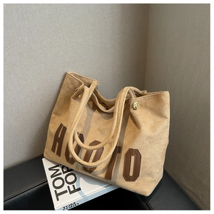 Detailed view of light brown suede tote bag with dark brown HUOTU leather letter patch