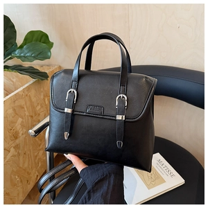 British retro black leather satchel on a chair with artistic Matisse book background