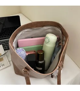 Spacious interior of a brown faux leather tote bag with laptop and essentials