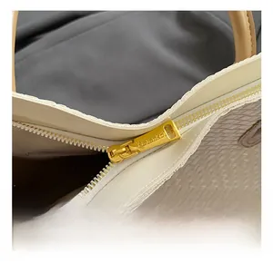 Macro shot of premium gold hardware zipper and woven texture on beige tote bag