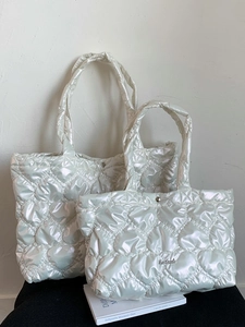 Set of two pearl white heart-quilted tote bags with metallic finish and logo plaque