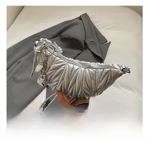 Détail du sac croissant argenté matelassé avec breloque cœur et bandoulière nouée