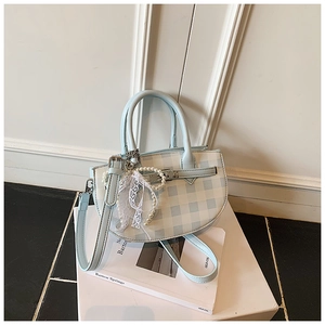 Detail of light blue checkered bucket bag with pearl charm and lace bow accessory
