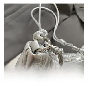 Détails du sac argenté métallisé plissé avec surpiqûres et crochet en métal rond
