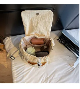 Interior view showing the large capacity and functional compartments of the cream backpack