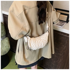 Détail du sac à bandoulière blanc plissé en demi-lune avec texture feuille et nœud